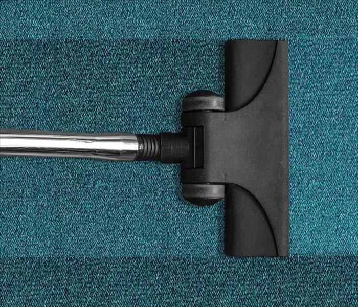 teal carpet getting cleaned by a carpet cleaner